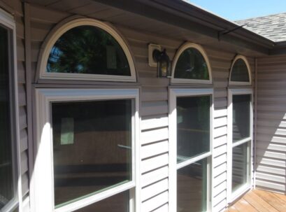 This exterior view showcases window replacement St. Louis, MO, with elegant arched transoms and clean white frames that enhance the home’s classic appeal