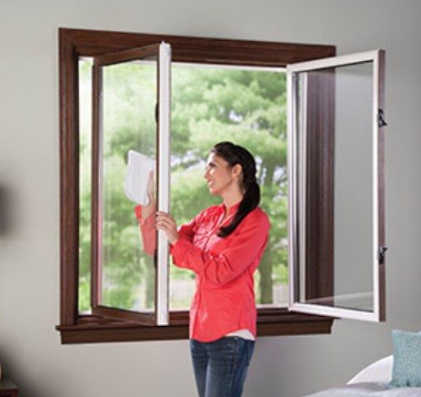 homeowner-opens-casement-windows-after-window-replacement-st-louis-mo A homeowner opens bright casement windows for fresh air after window replacement St. Louis, MO